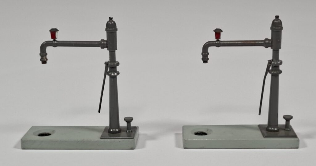 Swarte (?) steam loco accessories: two swivelling wood/metal water cranes, 1950s